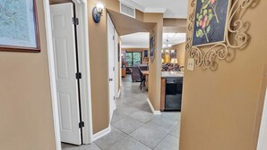 A hallway with a white door, a dining area with a table and chairs, and a kitchen area with a dishwasher. - two bedroom condo sleeps 4 persons (Gatlinburg)