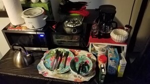 Et køkken med mikroovn, brødrister, elkedel og kaffemaskine.