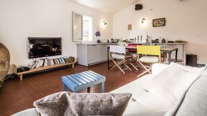 Ein modernes Wohnzimmer mit einer Couch, einem Couchtisch, einem Fernseher und einem Bücherregal.
