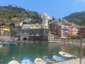 Une ville côtière dotée d’une tour historique, de bâtiments aux couleurs vives et de bateaux amarrés dans le port.