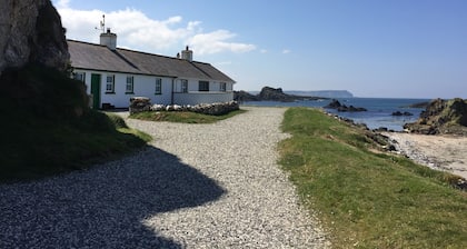 Vacker strandpromenadstuga, omfattande privata trädgårdar, fantastisk havsutsikt. 