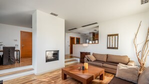 Een moderne woonkamer met een houten salontafel, een bank en een open haard.