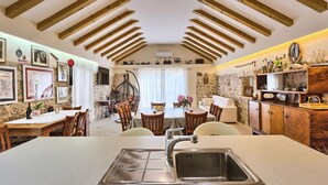 Una cocina amplia con una isla central, vigas de madera en el techo y una pared de piedra.