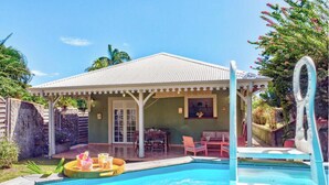 Une villa avec piscine, un espace salon extérieur et une terrasse couverte.