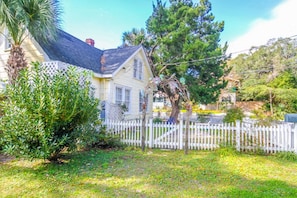 Situated in a suburban setting, this two-story house features a well-maintained garden and a white picket fence.