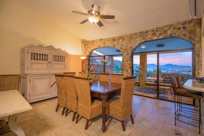 A dining area with a stone wall, a view of the city, and a ceiling fan. - Luxury Private Villa-  Walk to Town, Pedregal, WiFi... (Cabo San Lucas)