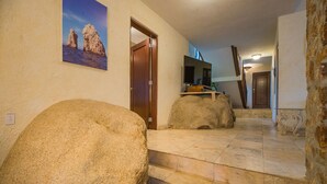 A hallway with stone steps, a wooden door, and a television on a stand. - Luxury Private Villa-  Walk to Town, Pedregal, WiFi... (Cabo San Lucas)