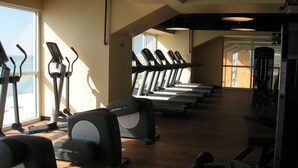 Ein Fitnessstudio mit Laufbändern, Crosstrainern und Kraftgeräten.
