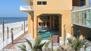 Ein mehrstöckiges Hotel mit Poolbereich, Balkonen und Blick auf den Strand.