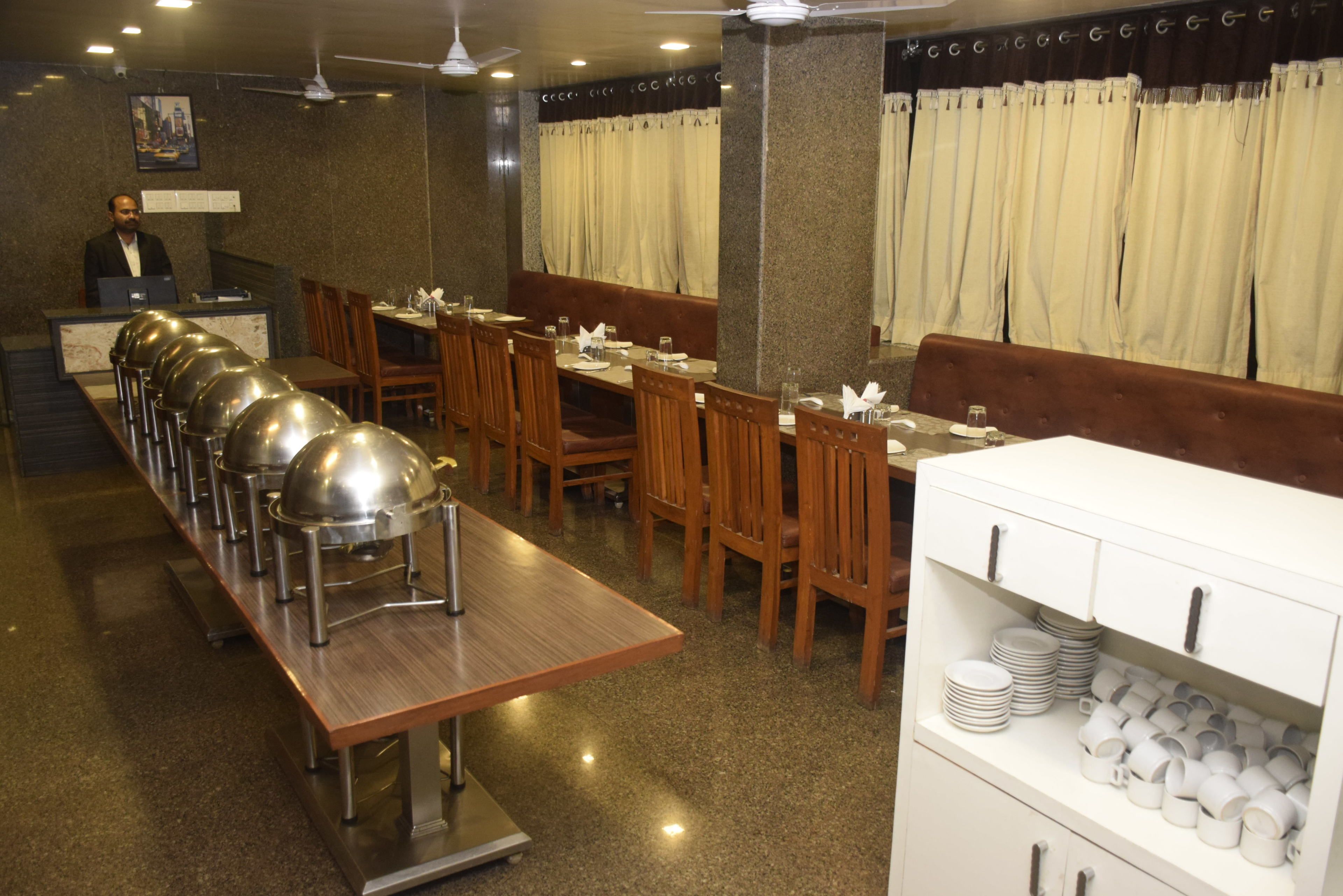 Un restaurante con una barra larga, varias mesas y una zona de bufé.