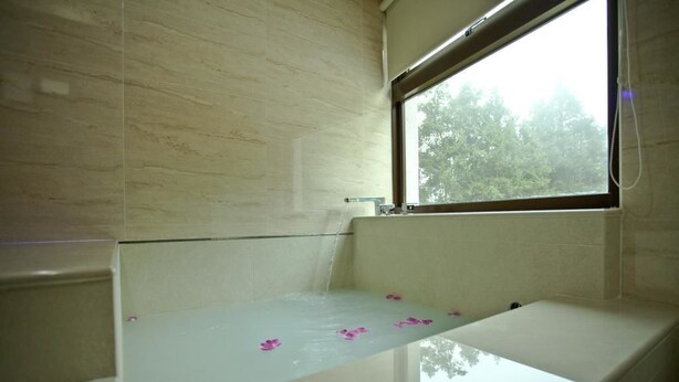 A bathroom with a bathtub, a window, and a mirror. - Sin Ging Hong Resort (Lugu)