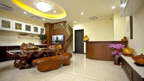 A spacious living area with a wooden coffee table, a television, and a staircase leading to an upper floor. - Sin Ging Hong Resort (Lugu)