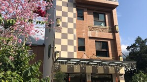 A multi-story building with a checkered facade, a balcony, and a Christmas tree at the entrance. - Sin Ging Hong Resort (Lugu)