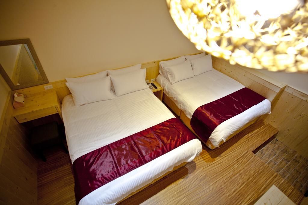 Two single beds with wooden headboards and nightstands, a mirror, and a woven light fixture.