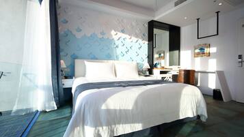 A modern hotel room with a large bed, a nightstand, a dresser, and a mirror.