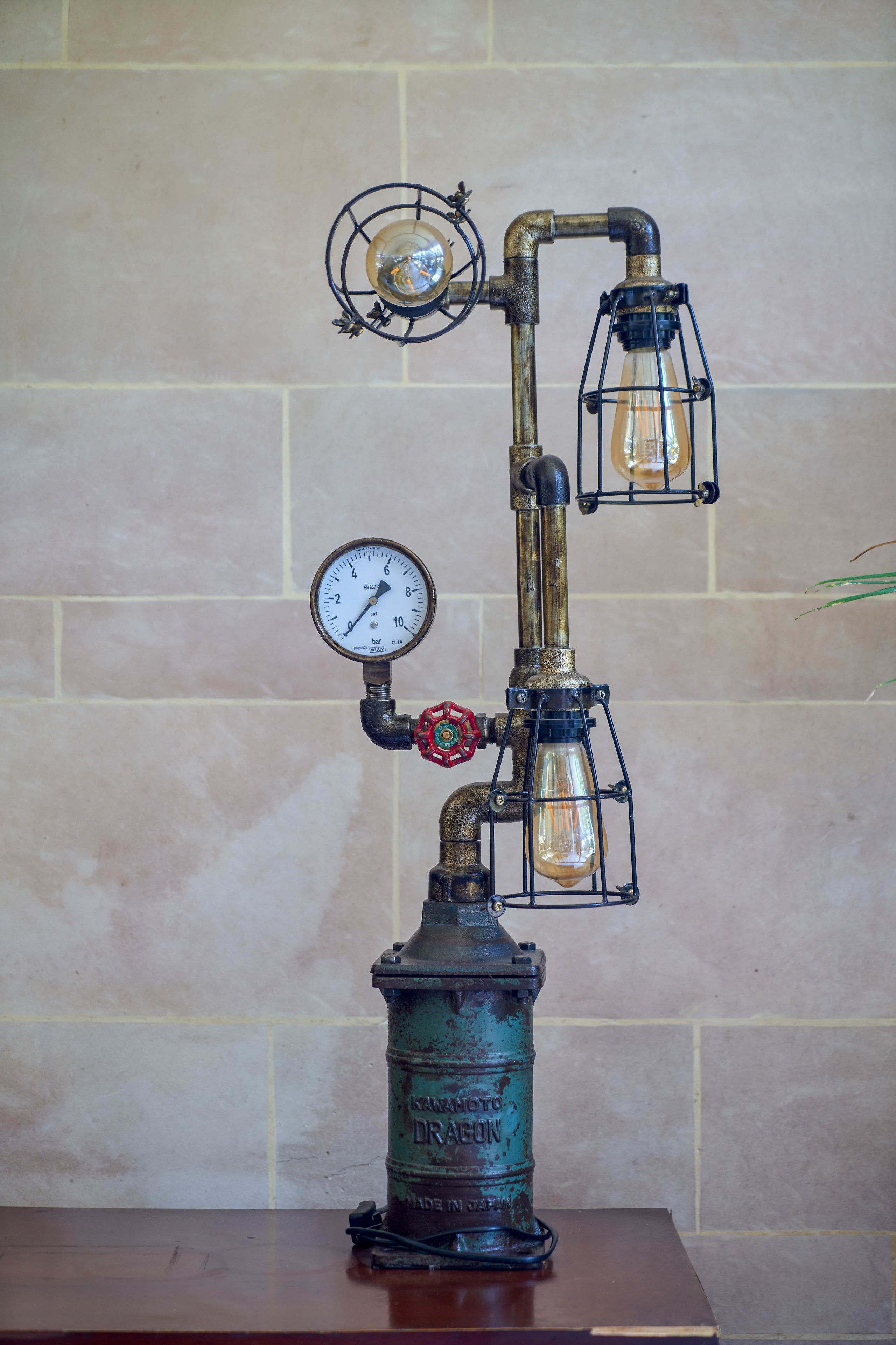 A vintage-style gas pump with a pressure gauge and two lantern-style lights.