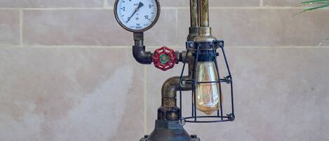 A vintage-style gas pump with a pressure gauge and two lantern-style lights.