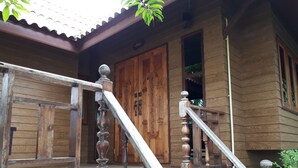 A wooden house with a wooden staircase and a large wooden door. - Chantara Resort (Bang Khonthi)