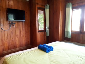 A wooden room with a bed, a flat-screen TV mounted on the wall, and a window with curtains. - Chantara Resort (Bang Khonthi)