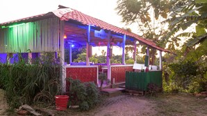 A rustic building with a red roof and a covered porch area. - Fanush Resort (Bandarban)