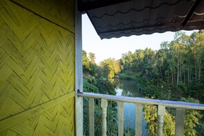 A wooden balcony with a view of a river and forest. - Fanush Resort (Bandarban)