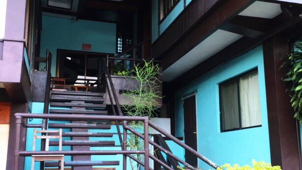 Un immeuble à plusieurs étages, avec un escalier menant à l’entrée.