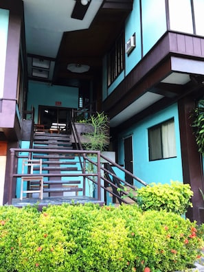 Un edificio de varios pisos con una escalera que lleva a la entrada.