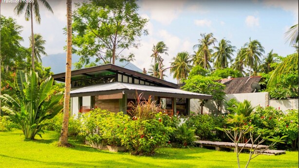 A modern house with a sloped roof, surrounded by lush greenery and palm trees. - SomeWhere Else Boutique Resort (Mambajao)