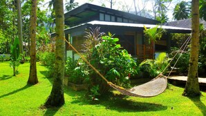 A house with a garden, a hammock, and palm trees. - SomeWhere Else Boutique Resort (Mambajao)
