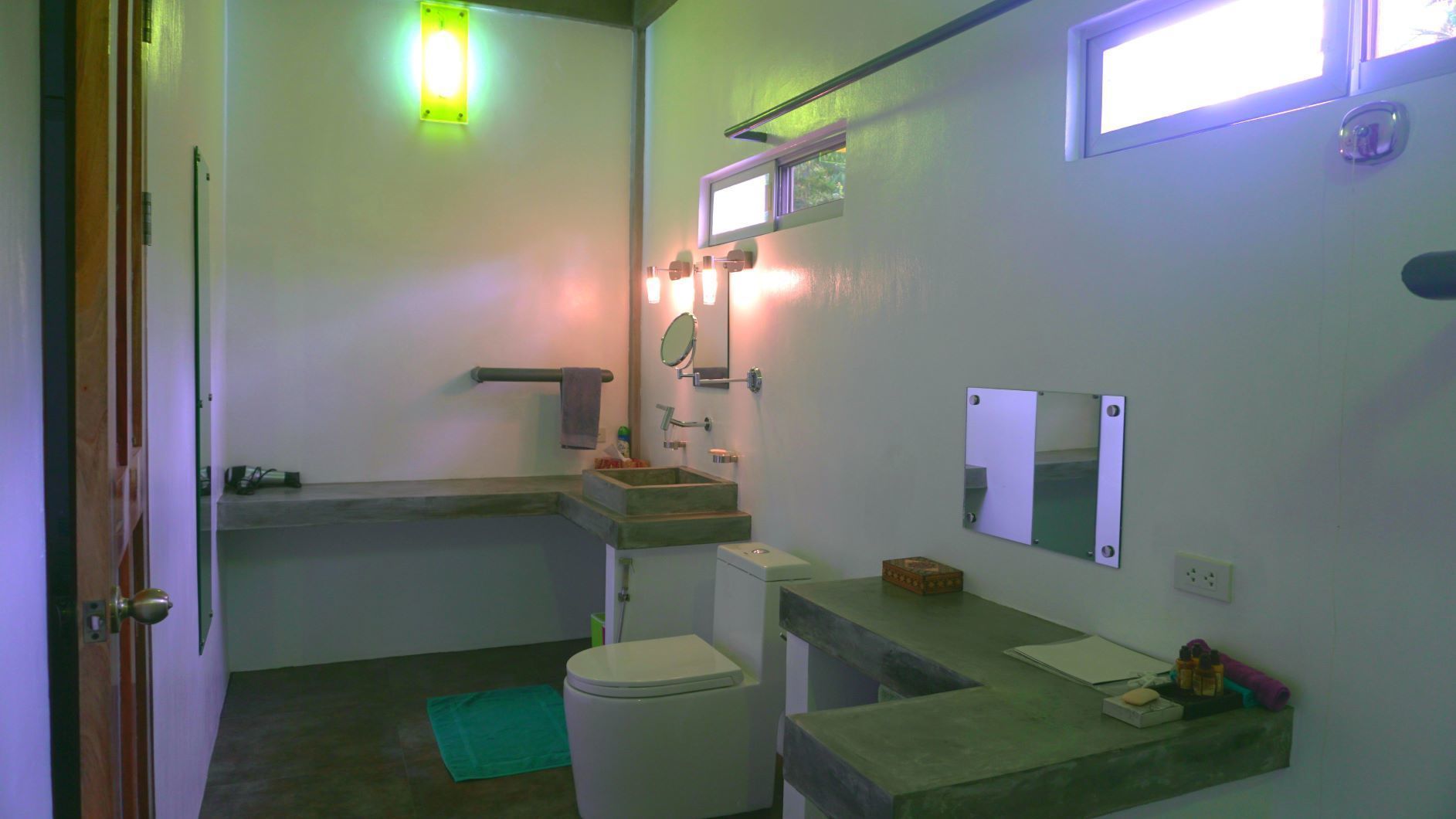 A compact bathroom with a toilet, sink, and mirror.