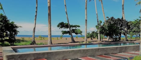 Una piscina al aire libre, sillones reclinables de piscina