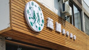 A storefront with a wooden facade and large glass windows. - Suzhou Chope Hostel (Suzhou)