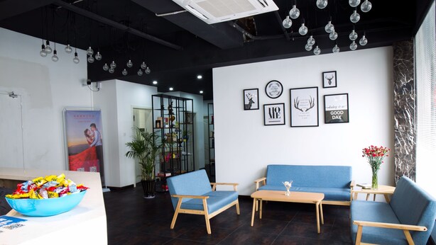 A modern lobby with a reception desk, blue seating area, and wall art. - Suzhou Chope Hostel (Suzhou)