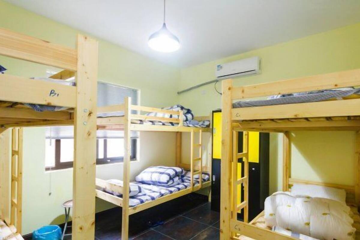 Un dormitorio con literas, una ventana y un equipo de aire acondicionado.