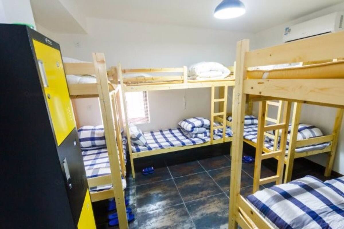 Un dormitorio con literas, un armario y una ventana con persianas.