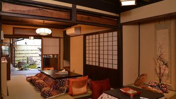 A traditional Japanese room with tatami flooring, a low table with a tray, and a sliding door with a grid pattern.