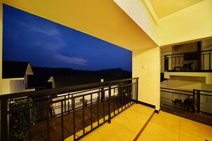A balcony with a view of a night sky and distant landscape.