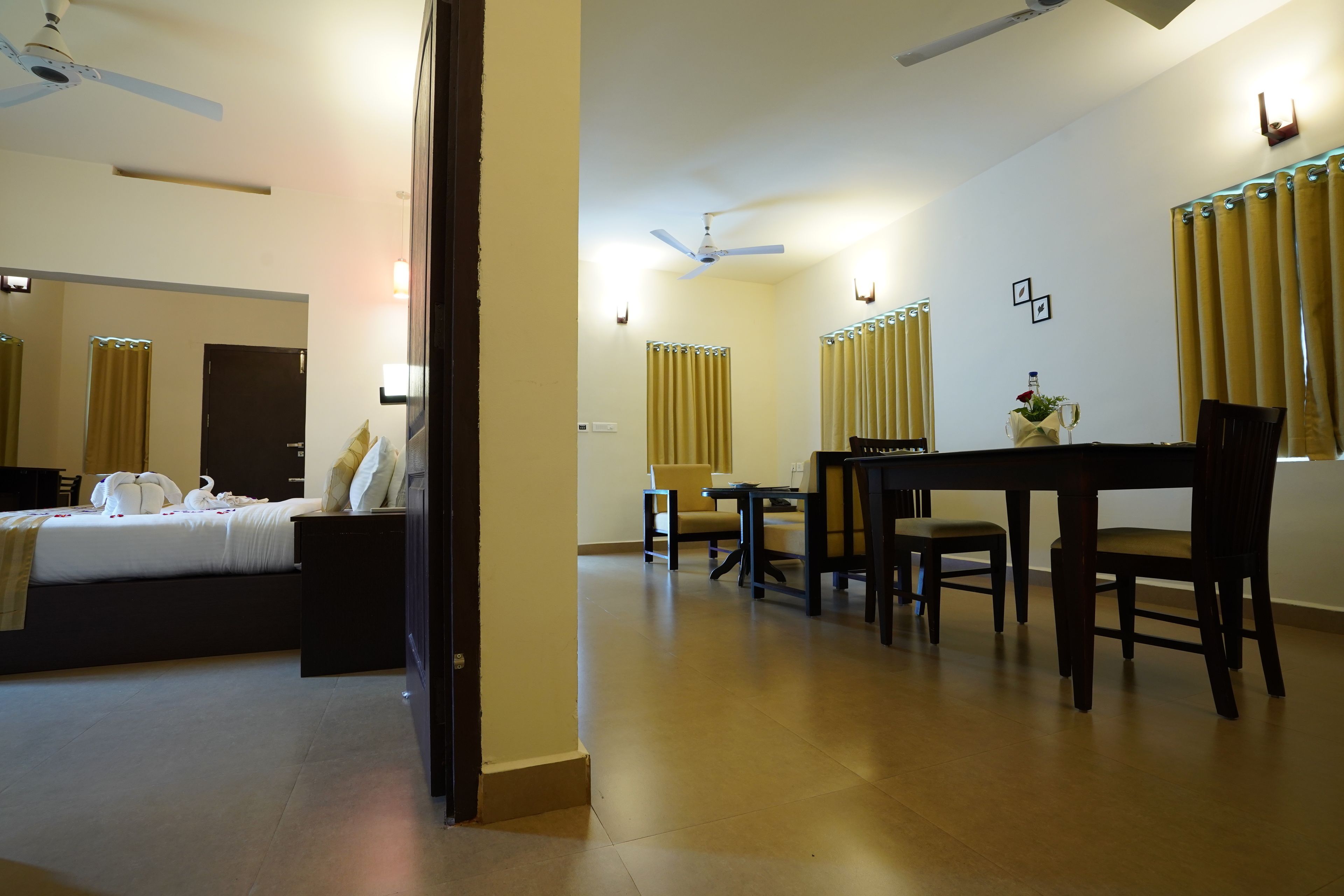 A hotel room with a bed, a desk, and a dining table.