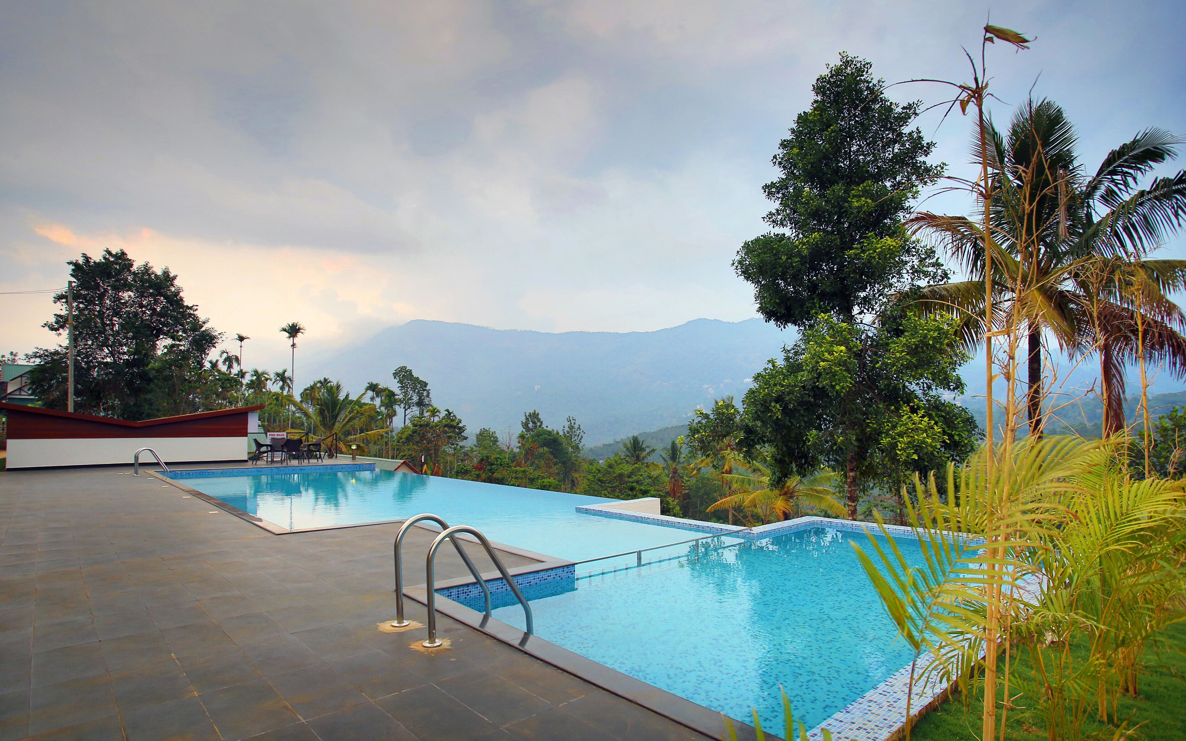 Une piscine avec vue sur les montagnes et les palmiers.