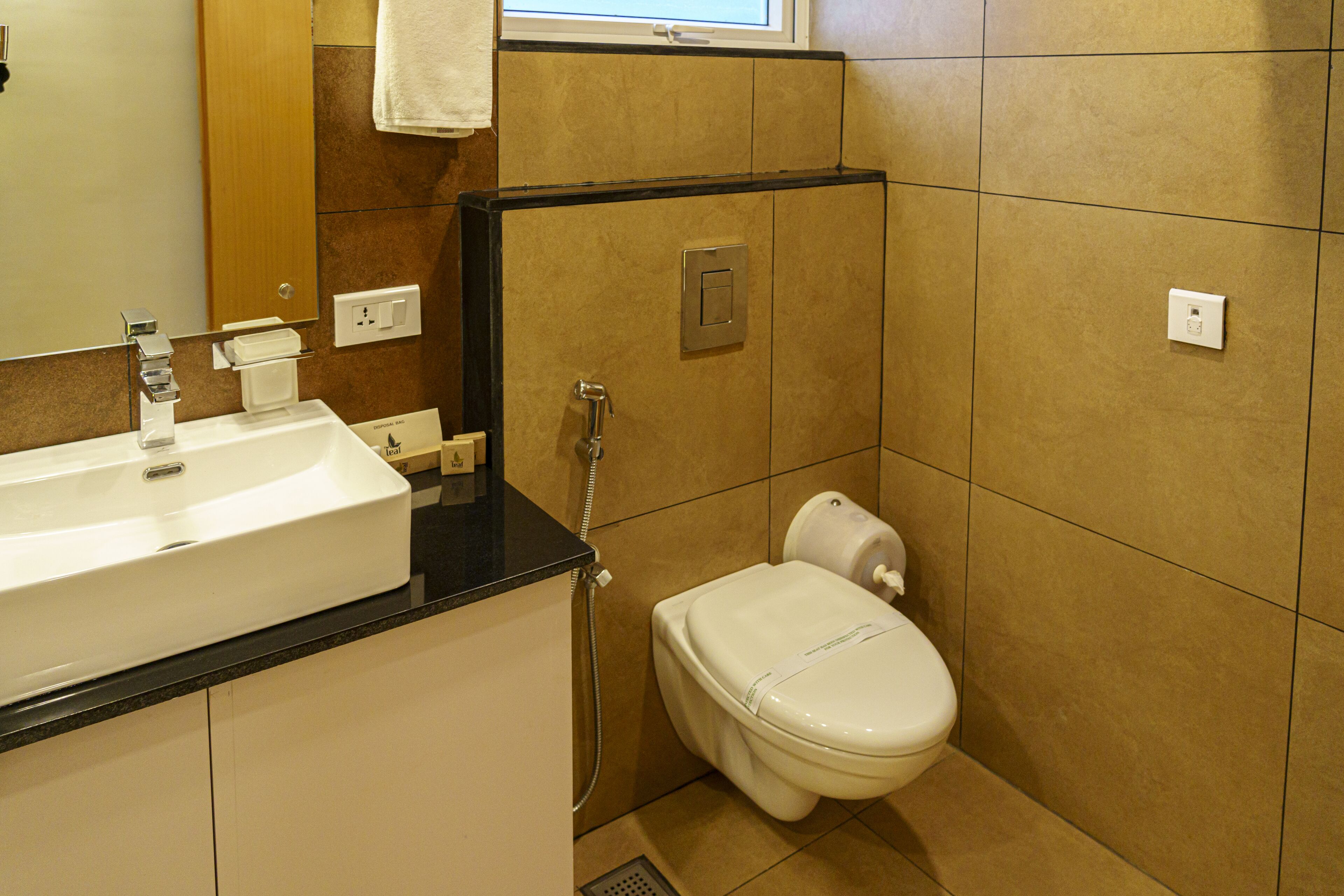 A bathroom with a sink, mirror, toilet, and shower.