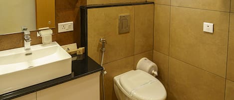 A bathroom with a sink, mirror, toilet, and shower.