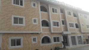 A multi-story building with the sign "Grand Emperor Hotels & Suites". - Grand Emperor Hotel (Lekki)