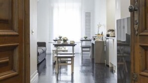 Una habitación amplia con piso pulido, una puerta de madera y un candelabro.