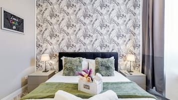 A hotel room with a bed, two bedside tables, a nightstand, a wall-mounted picture, and a window with curtains.