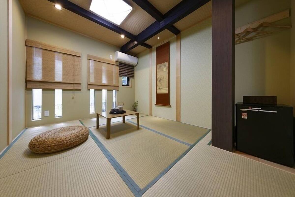A traditional Japanese room with tatami flooring, a low table, and a futon.