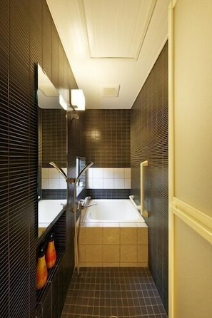 A narrow bathroom with a bathtub, a mirror, and a shelf with toiletries. - Kyoto Himawari Shijo Kawaramachi (Kyoto)