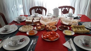 A dining table set with various food items and utensils, surrounded by chairs. - Risenlak Holiday Resort (Polonnaruwa)