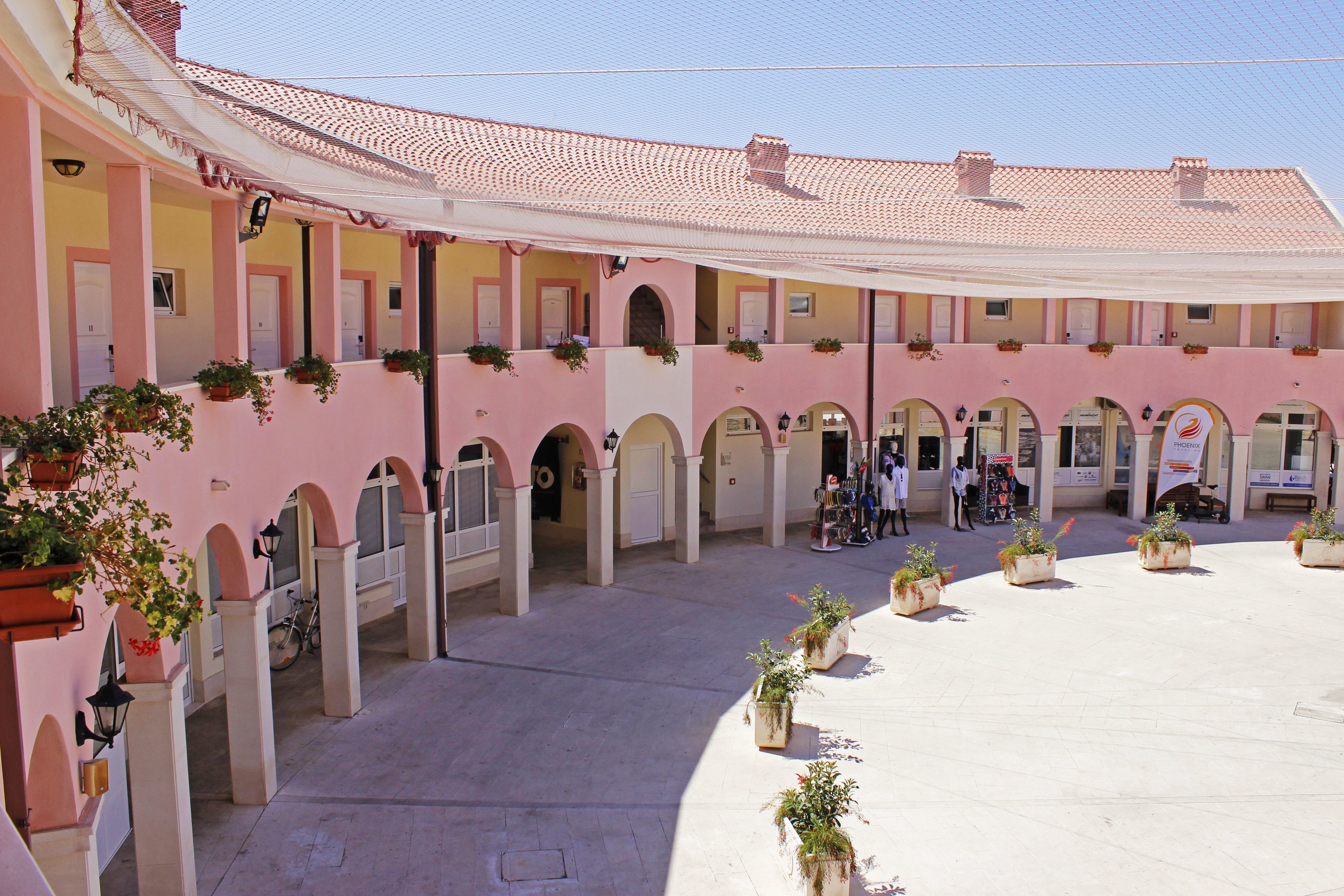 A courtyard with multiple arches and potted plants.