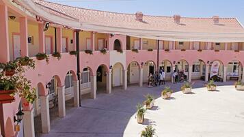 A courtyard with multiple arches and potted plants.
