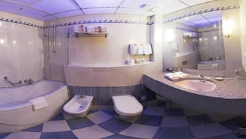 Een badkamer met een bad, toilet, wastafel en spiegel.